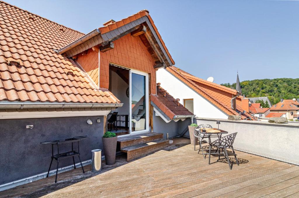 a wooden deck with chairs and a table on a house at Appartement Männerleben in Harztor