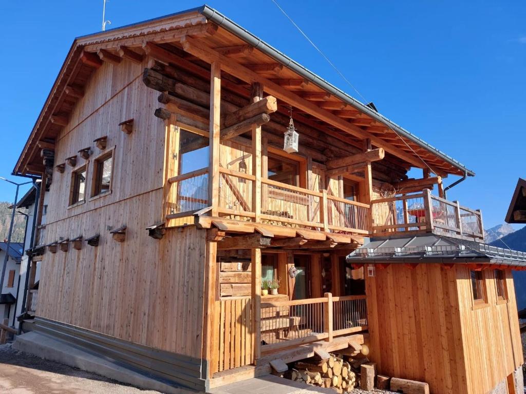 a large wooden house with a large balcony at Monolocale Carfon in Canale dʼAgordo