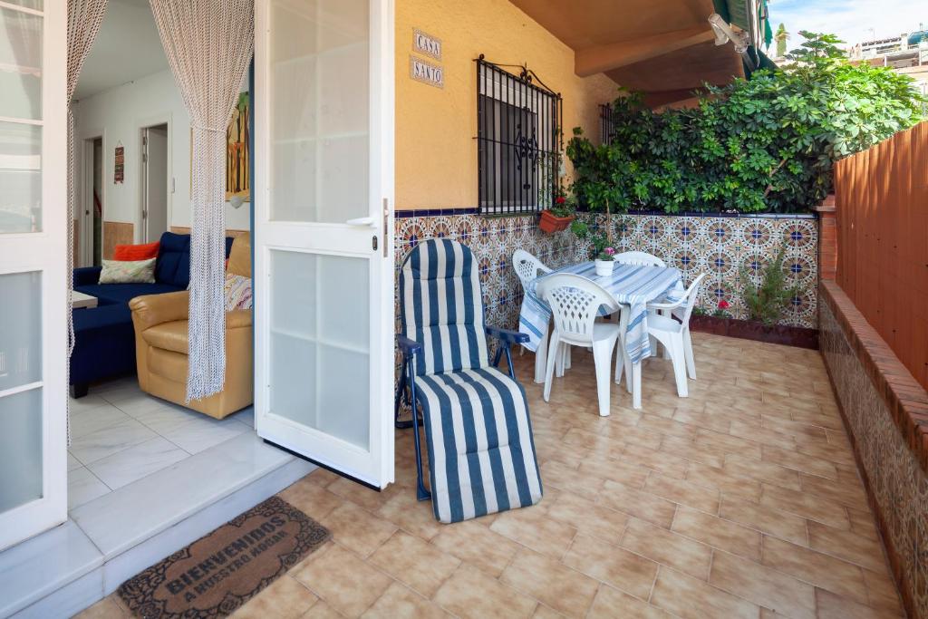 a patio with a table and chairs and a couch at Casa Santo front beach in Cala del Moral