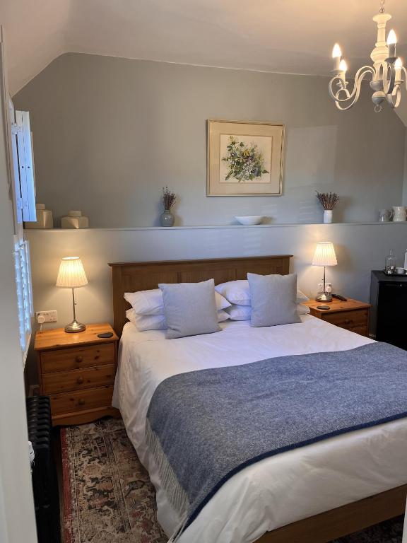 a bedroom with a large bed with two lamps and two tables at The Globe House in Broseley