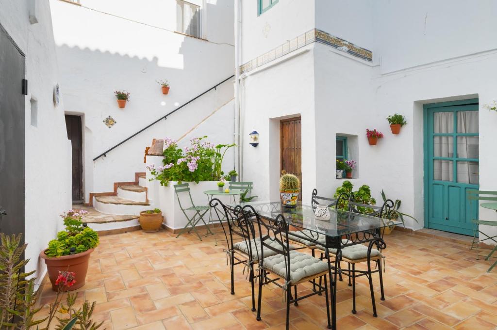 a patio with a table and chairs and stairs at Casa Catalán in Carmona