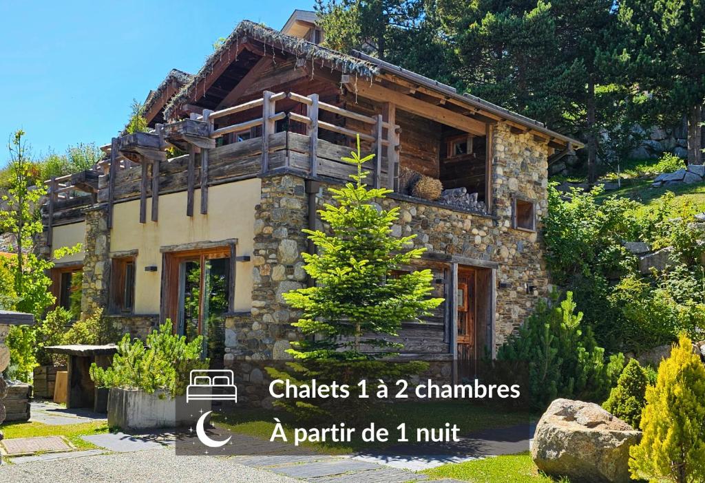 ein Steinhaus mit einem Baum davor in der Unterkunft Chalets Collection Greniers D'Alpages - Les Chalets Secrets in Bolquere