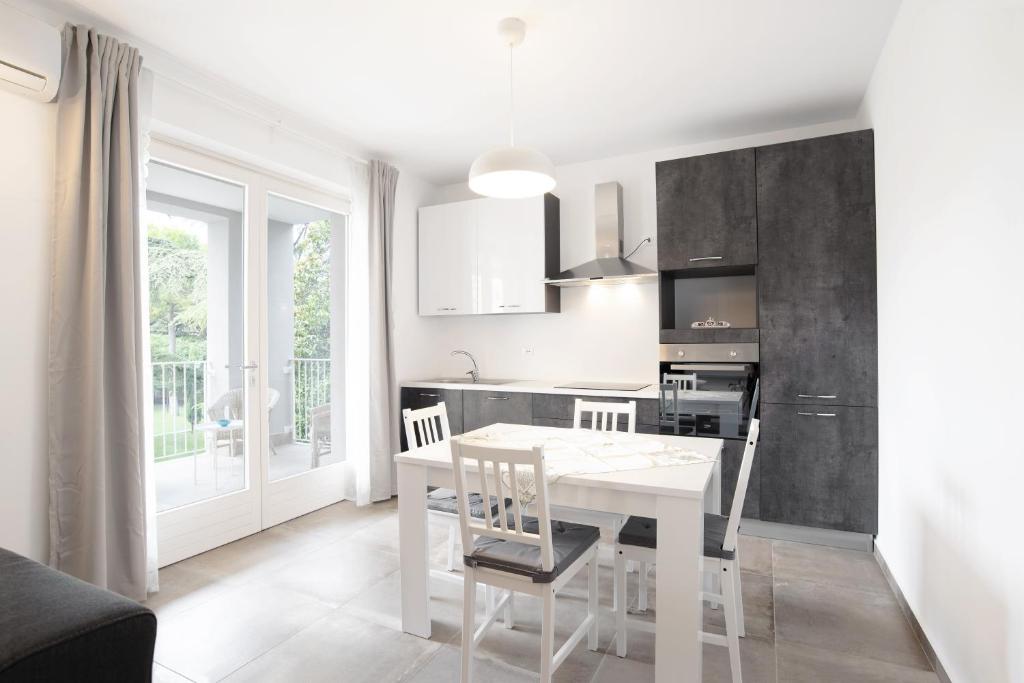 a kitchen and dining room with a white table and chairs at Appartamenti Dama 2 in Bardolino
