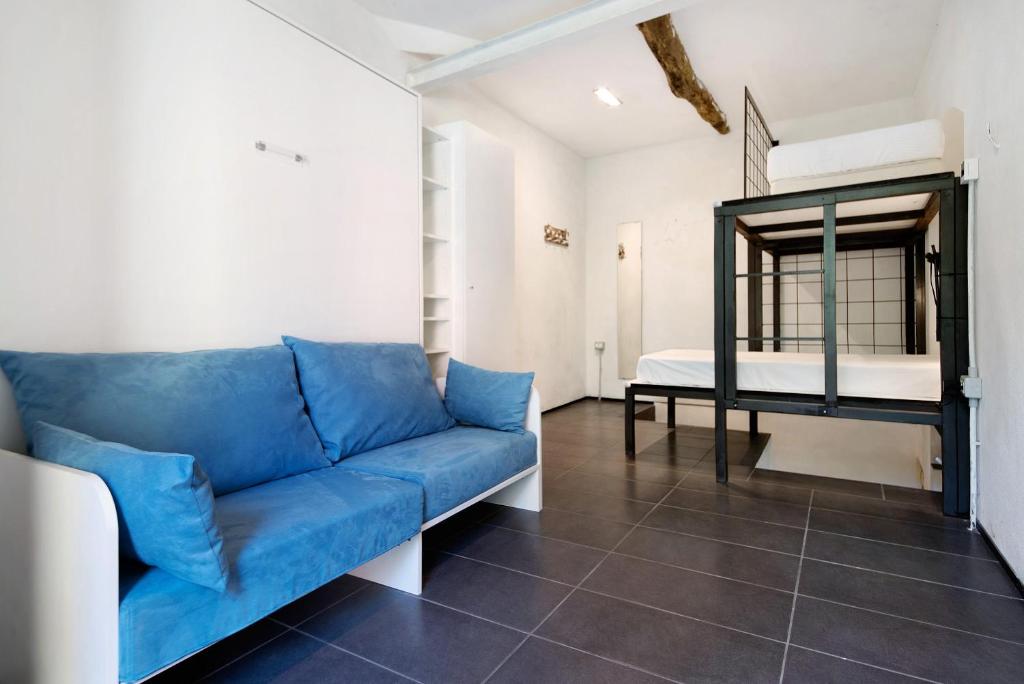 a living room with a blue couch and a bed at Beroni su due livelli in Bonassola