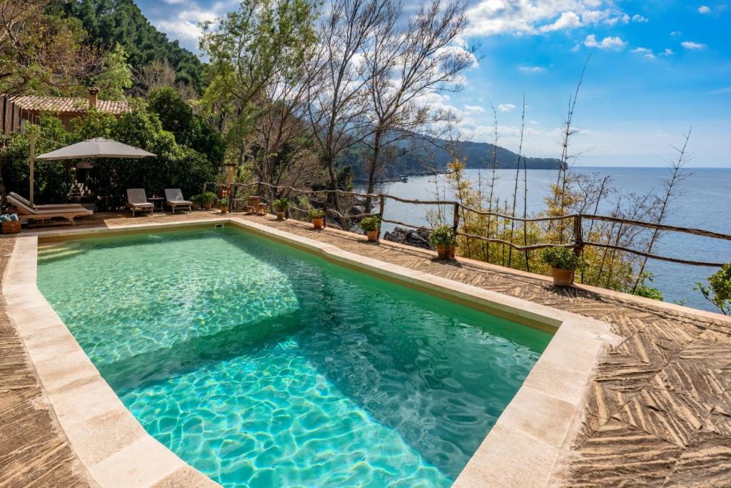 a swimming pool with a view of the water at Es Racó d'Alconàsser in Sóller