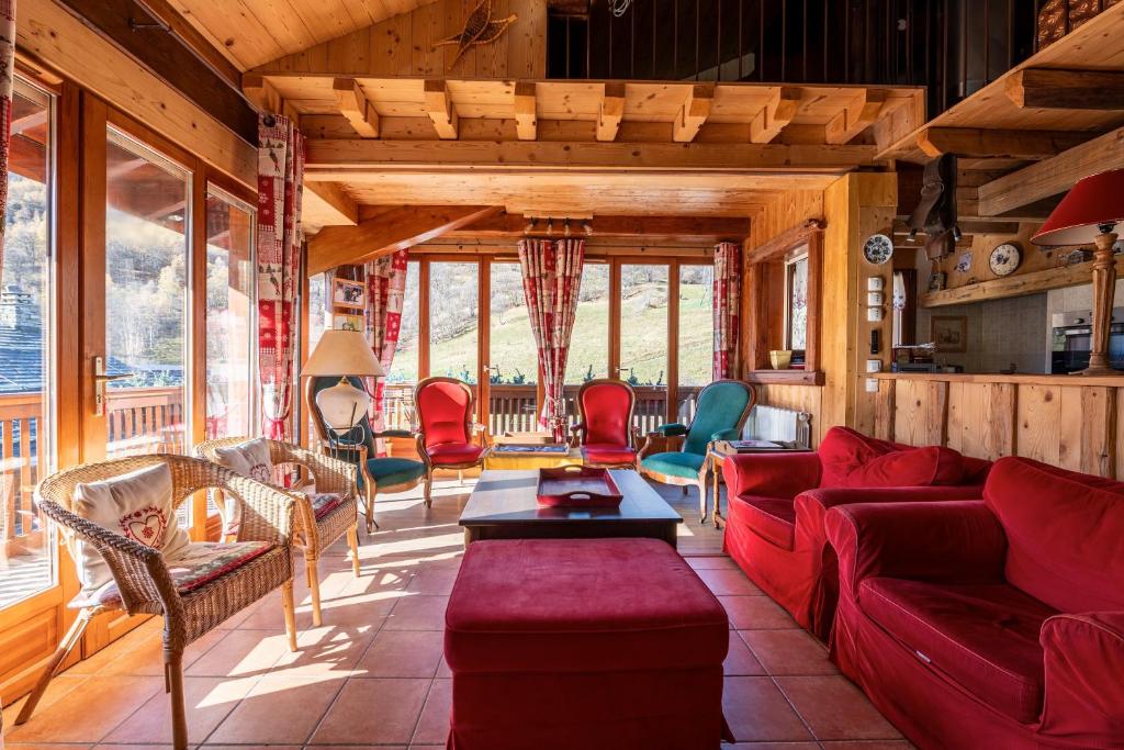 a living room with a red couch and chairs at Chalet Les Menuires Val Thorens in Praranger