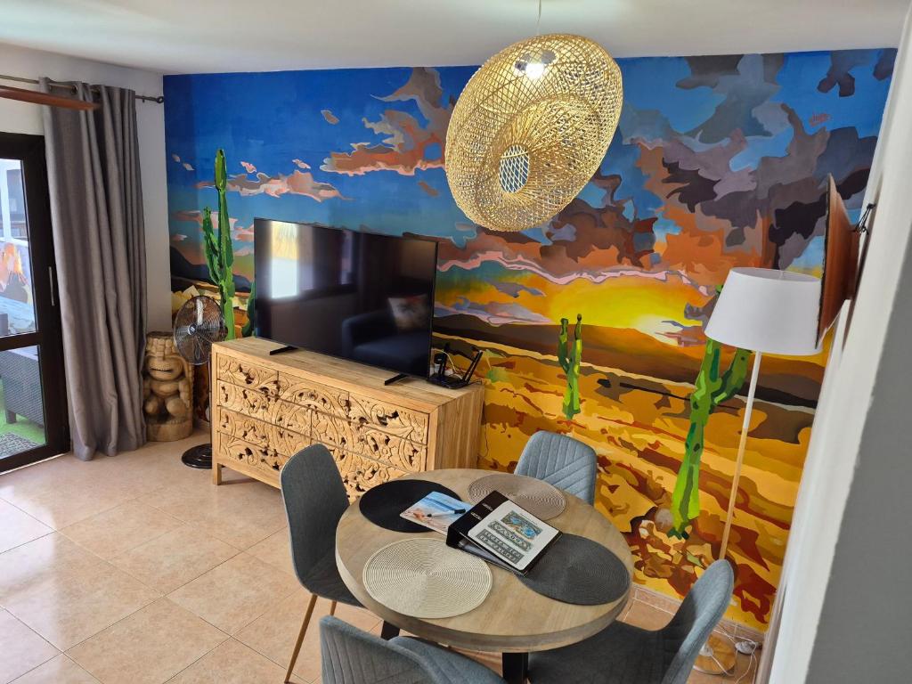 a dining room with a table and chairs and a mural at Casa de la Calma in Corralejo