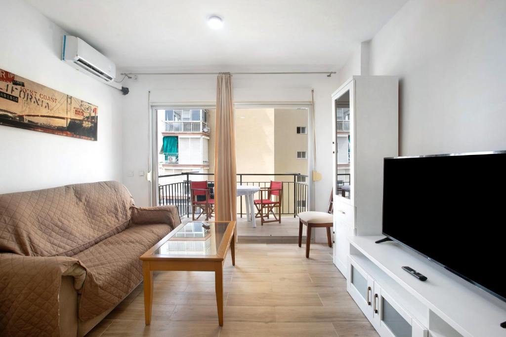 a living room with a couch and a flat screen tv at Apartamento Los Manantiales in Torremolinos