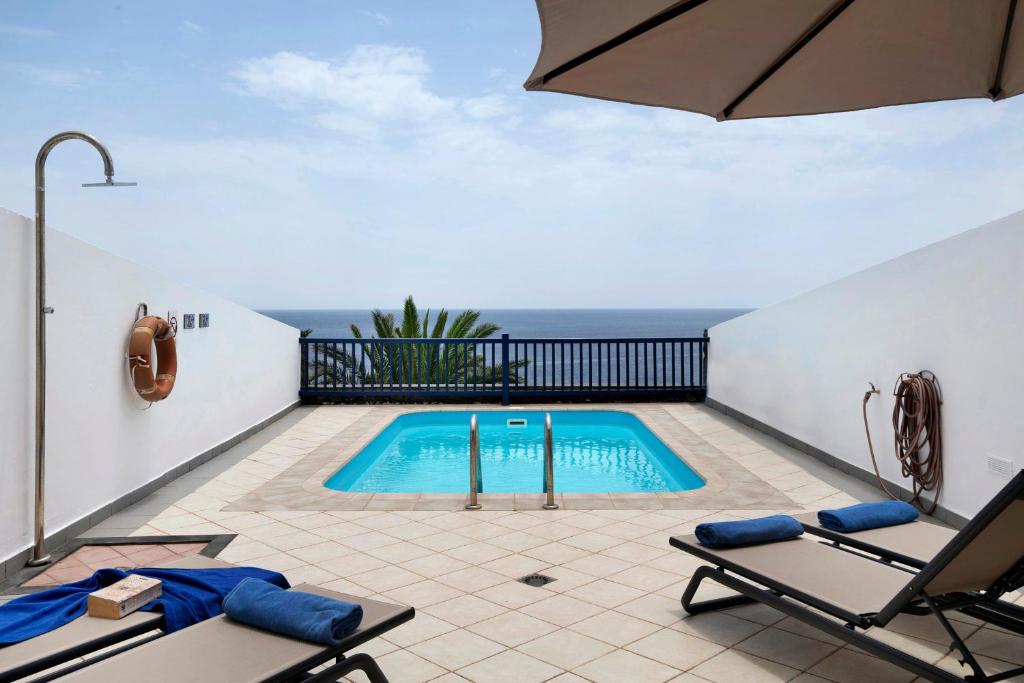 a swimming pool with a view of the ocean at Malvasia 22 in Puerto Calero