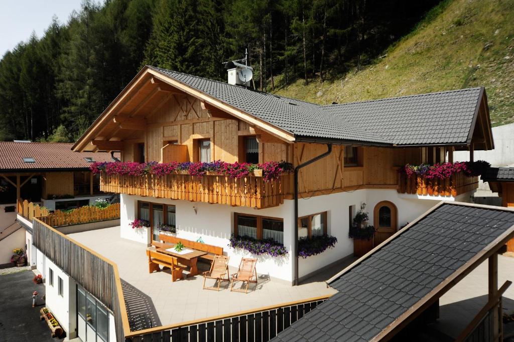 a house with a balcony with flowers on it at Apt Bergblick Hinterproslhof in Sarntal