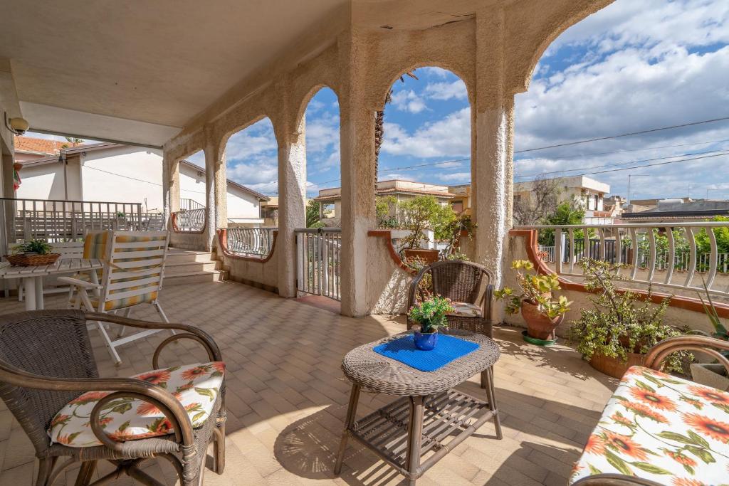 an outdoor patio with chairs and tables and a balcony at Fortezza Villa Azzurra in Agnone Bagni