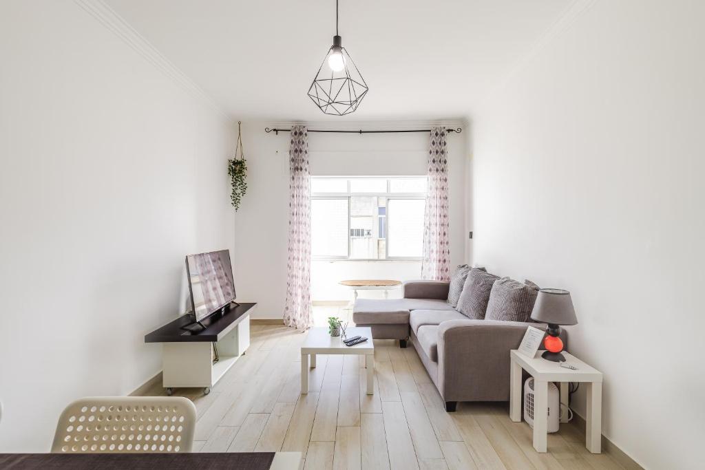 a living room with a couch and a table at Sleeptubal Moderne Accommodatie in Alhos Vedros