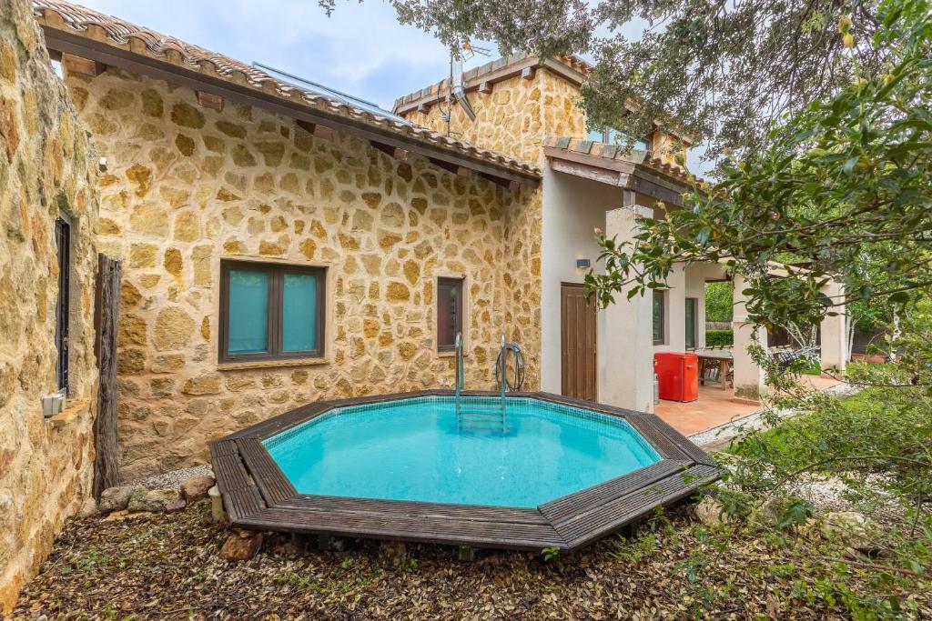 an outdoor swimming pool in front of a house at El Herrén Del Abuelo in Vegas de Matute