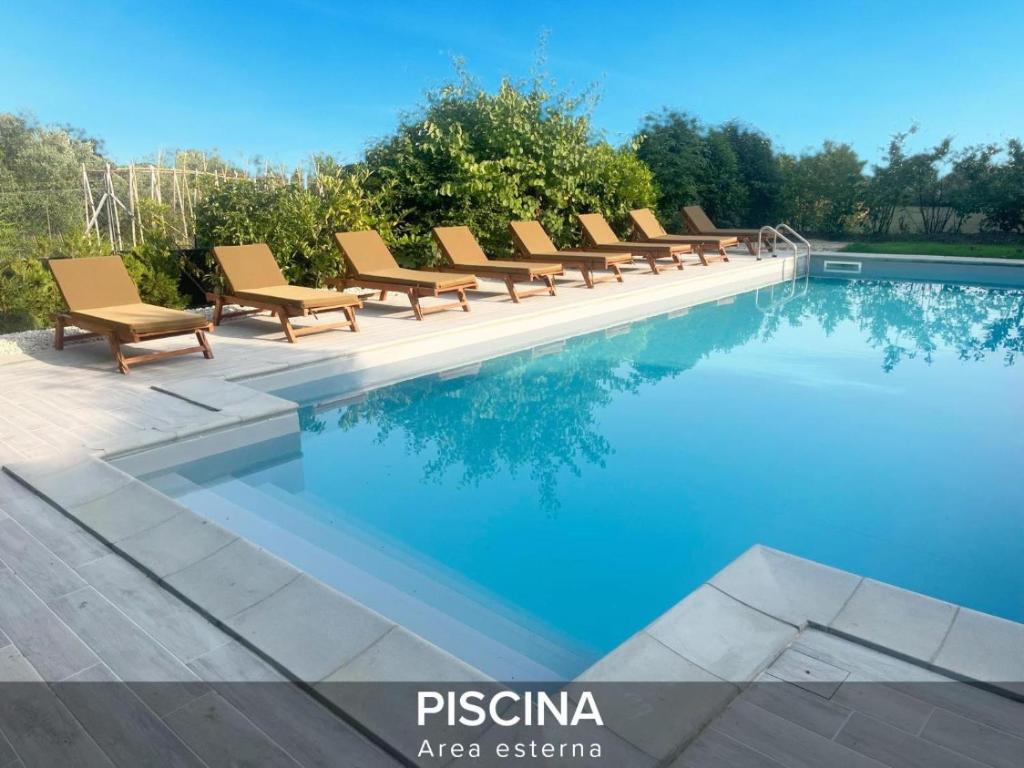 a row of chairs sitting next to a swimming pool at Villa Gelsi a Pesaro in Pesaro