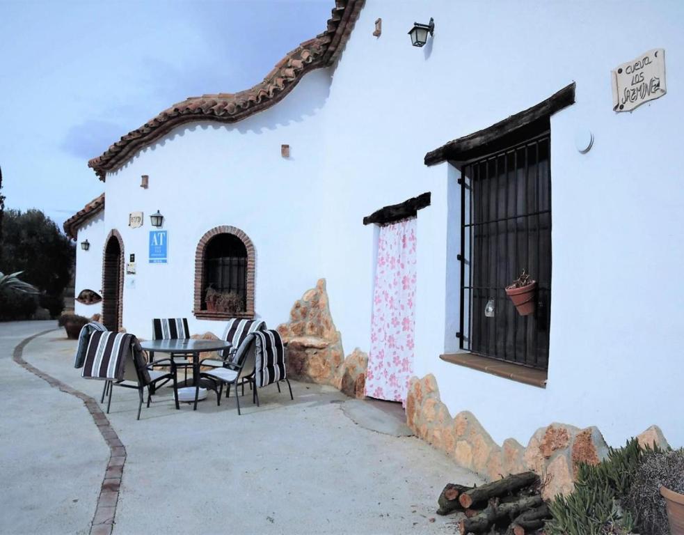 a patio with a table and chairs in front of a building at Los Jazmines in Benalúa de Guadix
