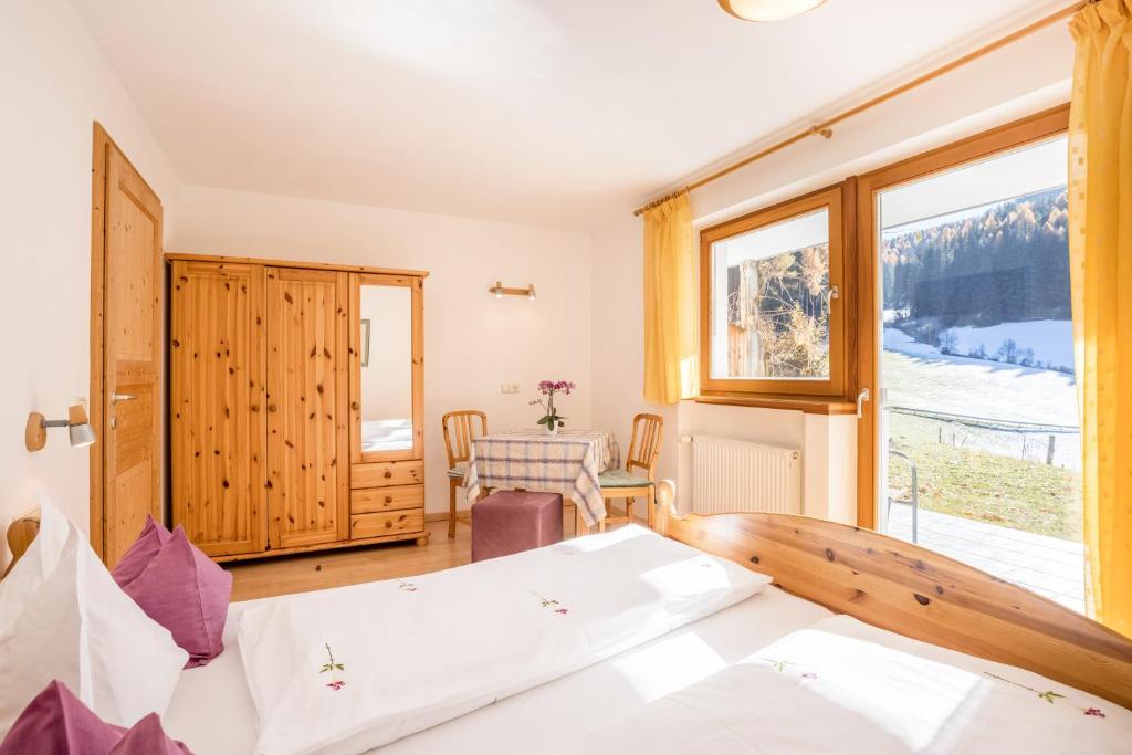 a bedroom with a bed and a large window at Lettnerhof bnb Family Suite 2 in Monguelfo