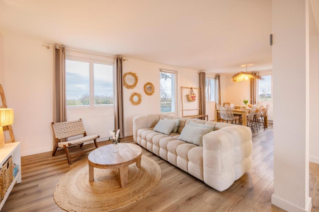 a living room with a couch and a table at Lividig Bleue en face de la mer in Brignogan-Plage