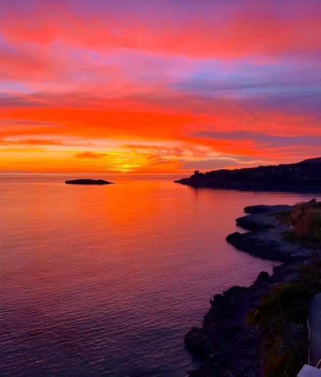 a sunset over a body of water with a island at Mare Azzurro in Marina di Camerota