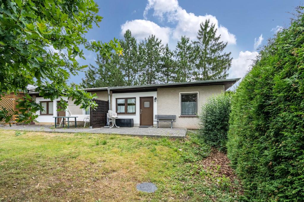 a house with a patio and a yard at Bungalow 131 in Zeulenroda