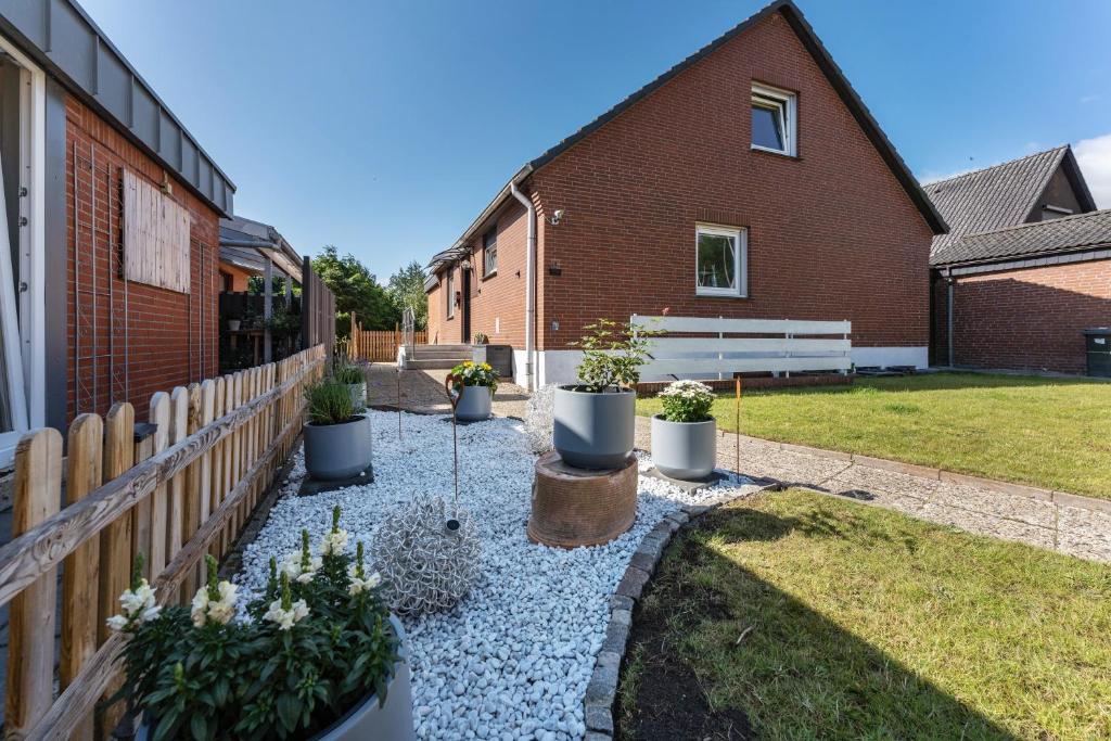 a garden with potted plants and a bench next to a building at Ferienwohnung Ostseeclick in Damp