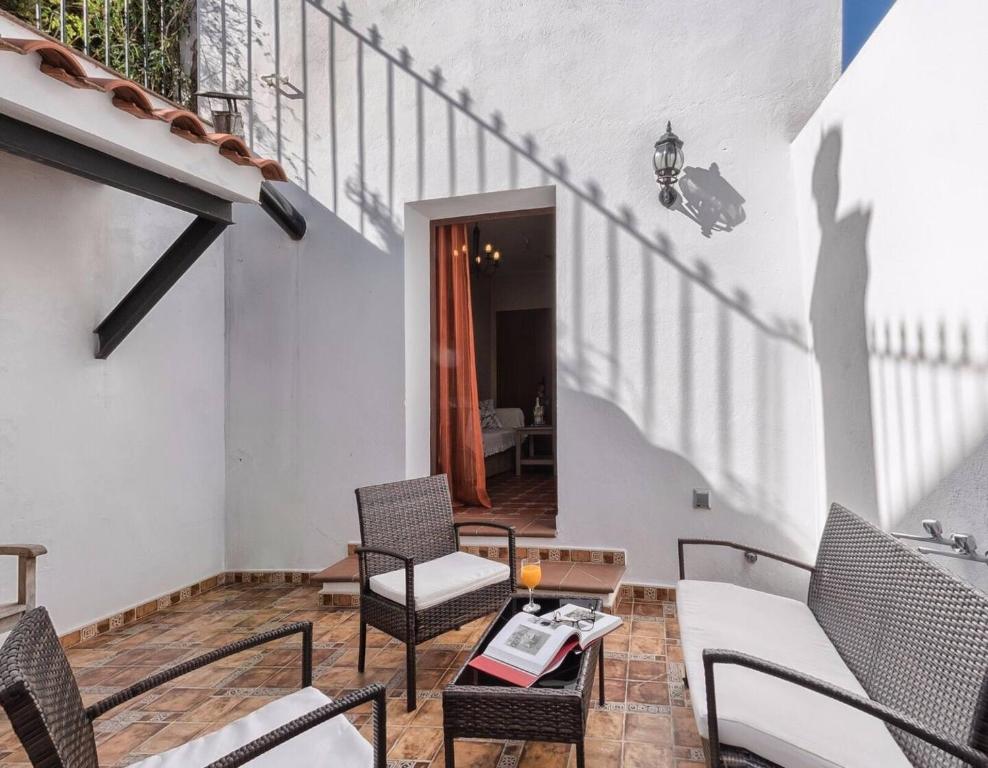 a patio with chairs and a table and a staircase at Los Placeres Del Paladin in Zufre