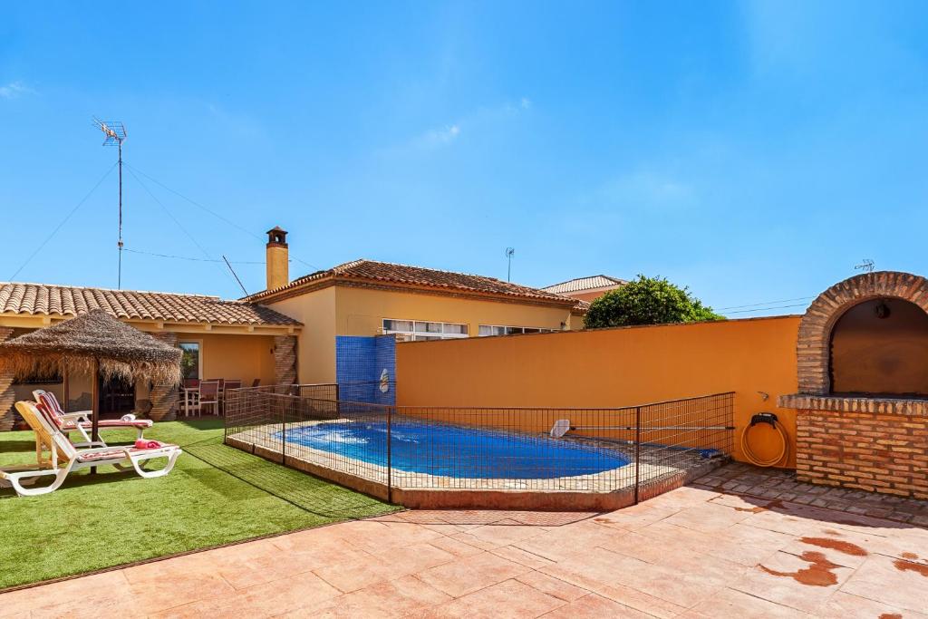 a swimming pool in the backyard of a house at Chalet Rocío - solo familias in Conil de la Frontera