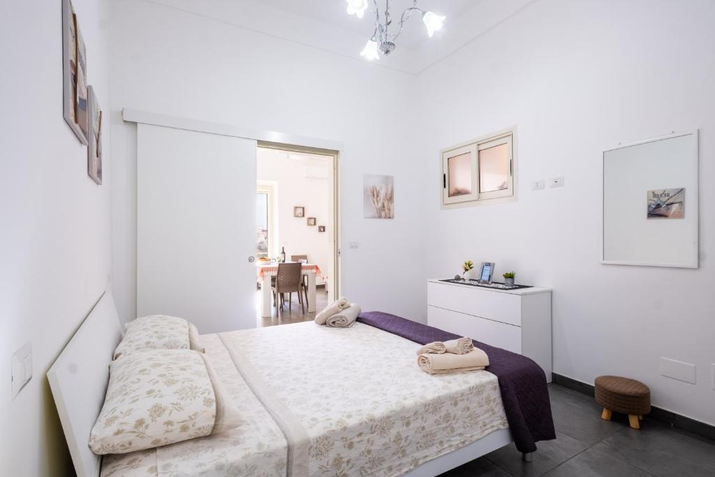 a white bedroom with a bed and a table at Casa Vacanze Lu Rizzaru in Nardò