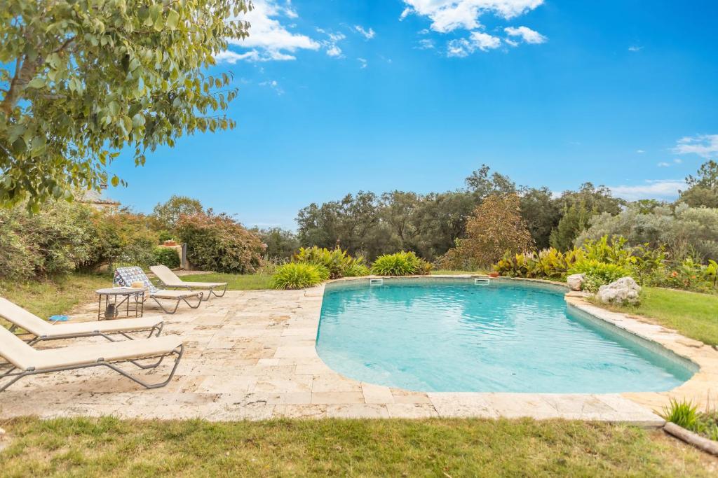 a swimming pool with two lounge chairs and a table at Mas Vinyoles 2 in Montnegre