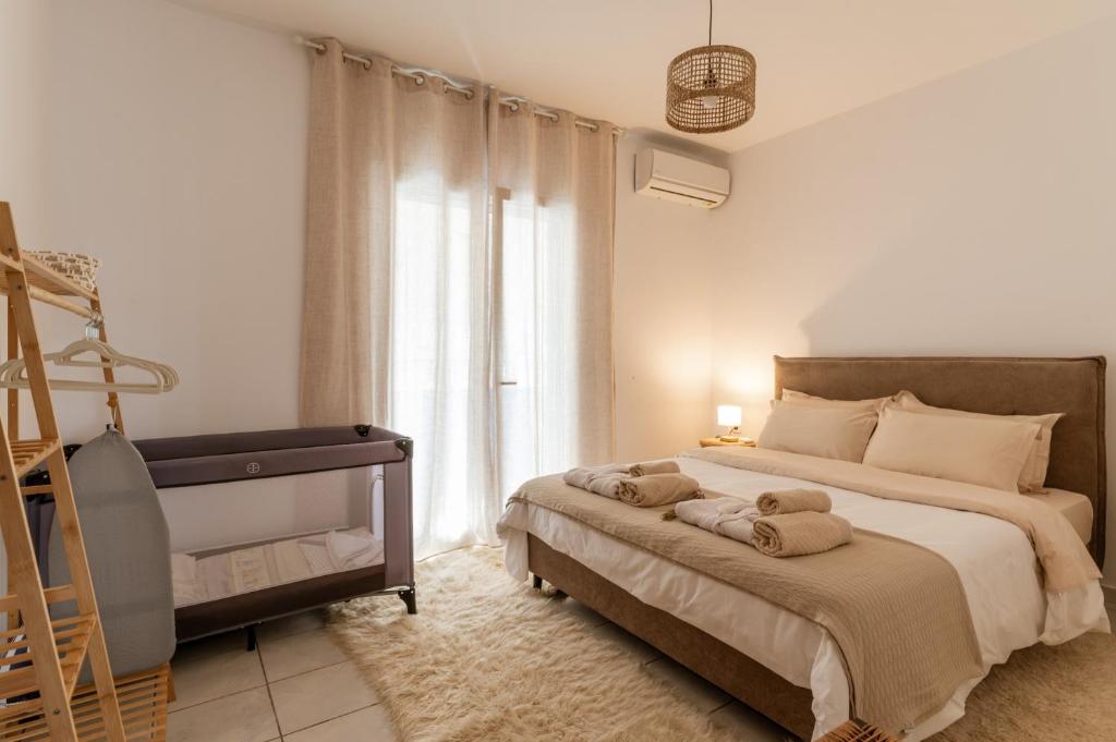 a bedroom with a bed with towels on it at Joan Serenity Apartment in Porto Heli