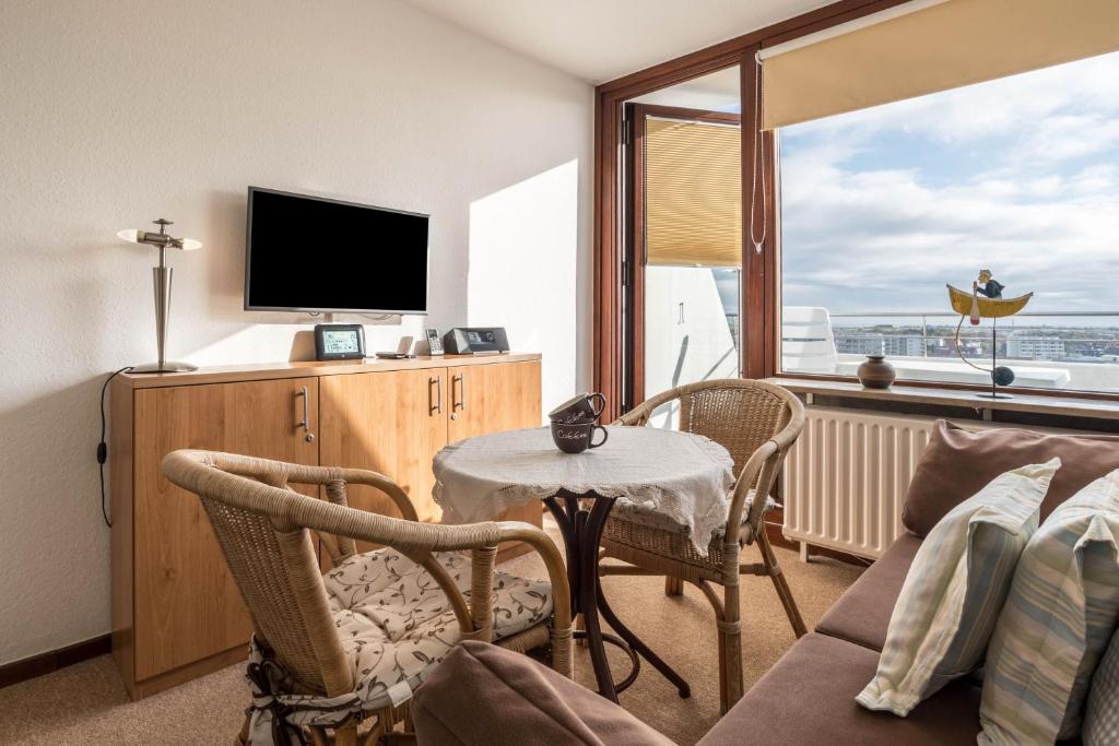 a living room with a table and a television at Fewo Blick über Sylt in Westerland