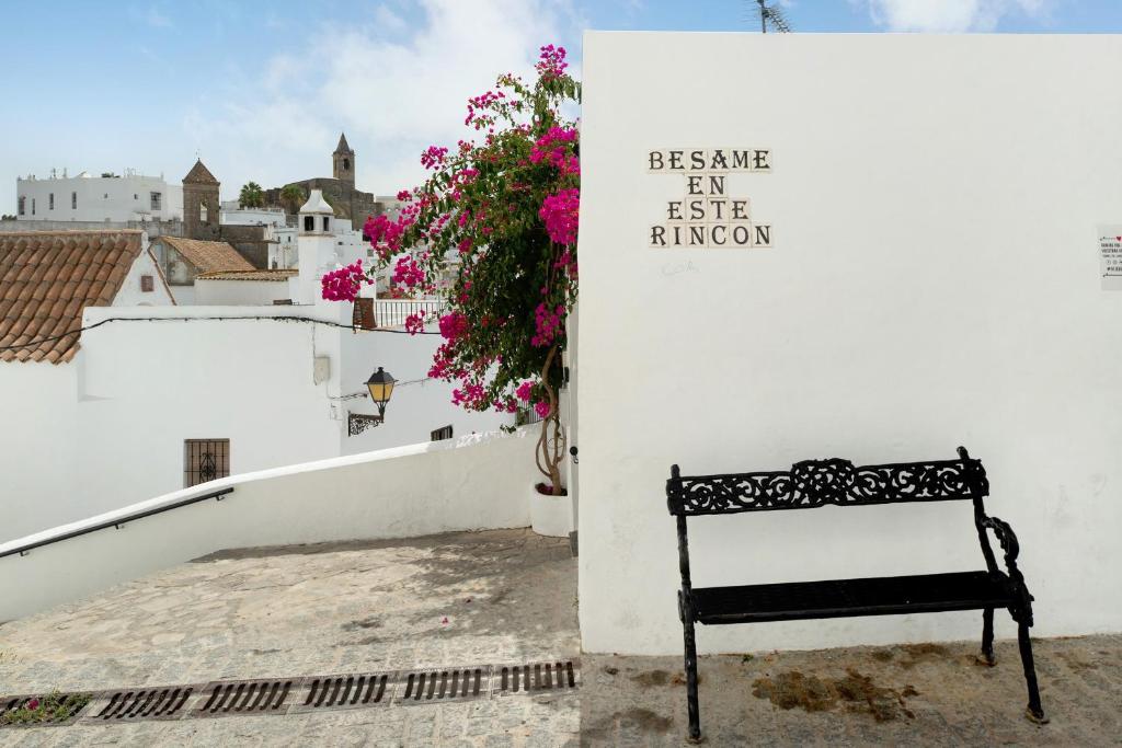 a bench sitting on a balcony with flowers at Casa Rincón del Beso in Vejer de la Frontera