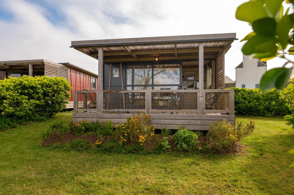 a small house with a porch and a deck at Chalet 25m2 - La Vieille in Plouhinec
