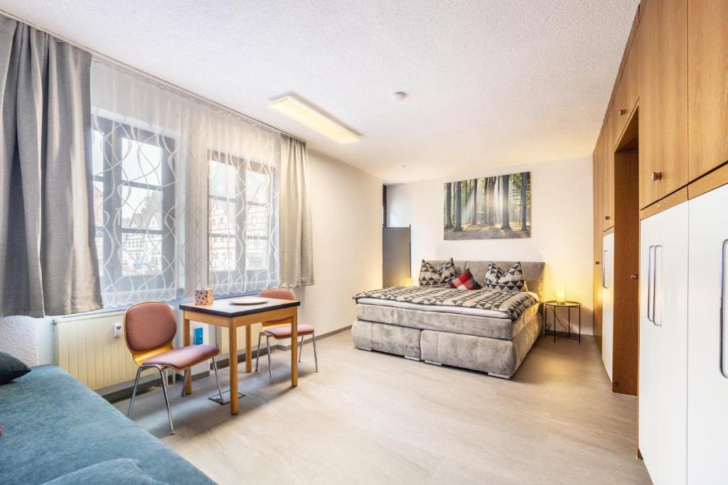 a hotel room with a bed and a table and chairs at Ferienwohnung Brunnenblick in Pottenstein