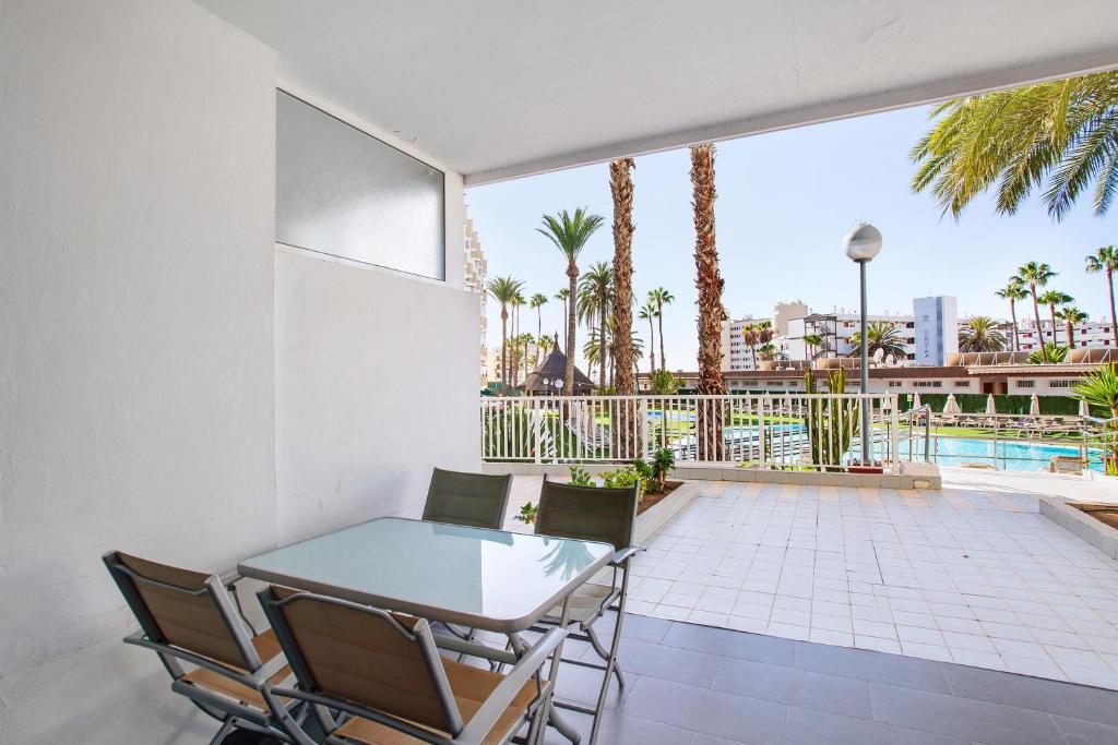 a patio with a table and chairs and a pool at Beautiful Apartment 1115 Central in San Bartolomé