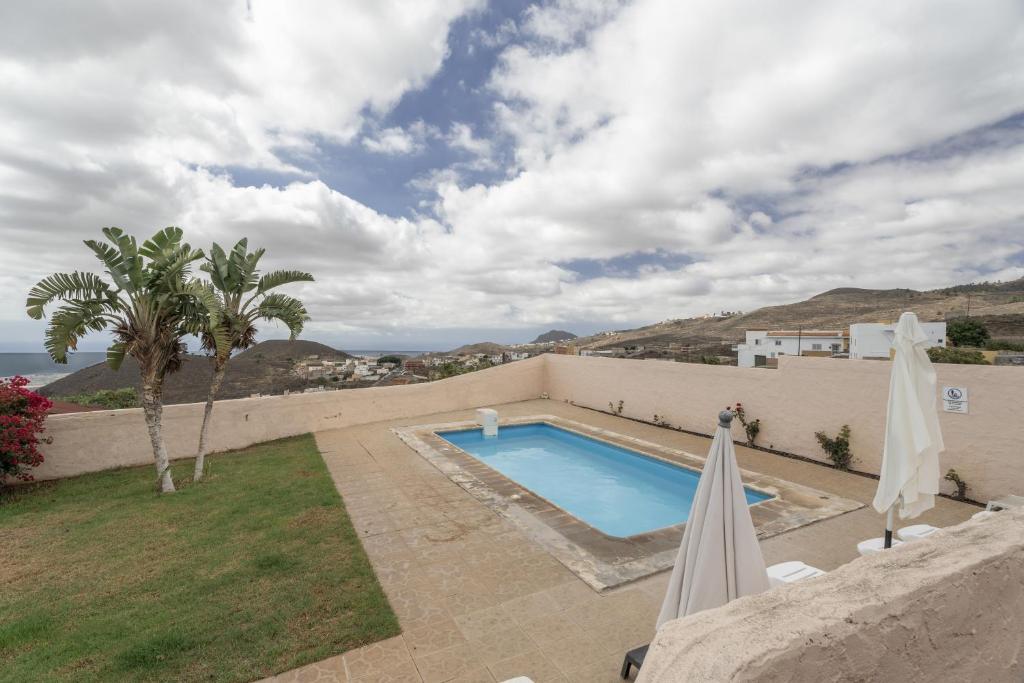 a swimming pool on the side of a house at Casa El Pinito No Groups Under 27 in Tamaide