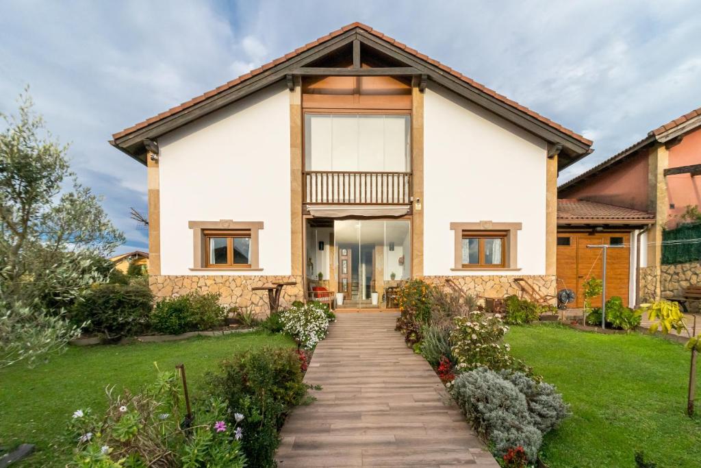 a home with a walkway leading to the front door at Casa Rural Alojamientos Marte in Hinojedo