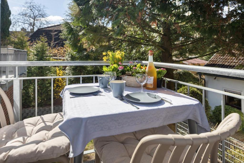 a table with plates and a bottle of wine on a balcony at Apartment am Tor zu Hamburg in Neu Wulmstorf
