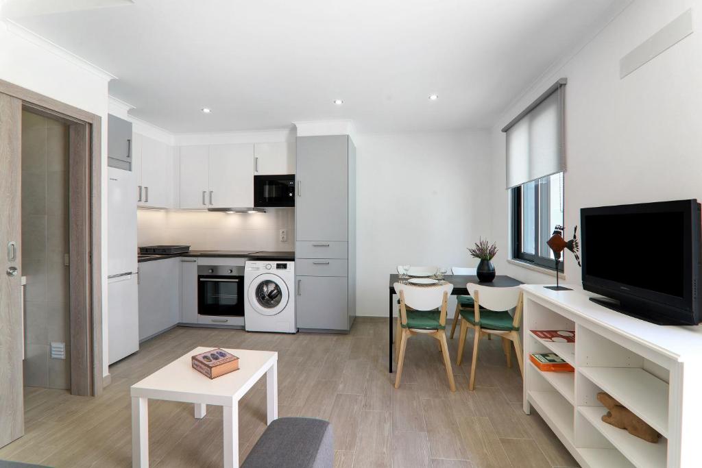 a living room with a kitchen and a dining room at Casa Lopes in Fuzeta
