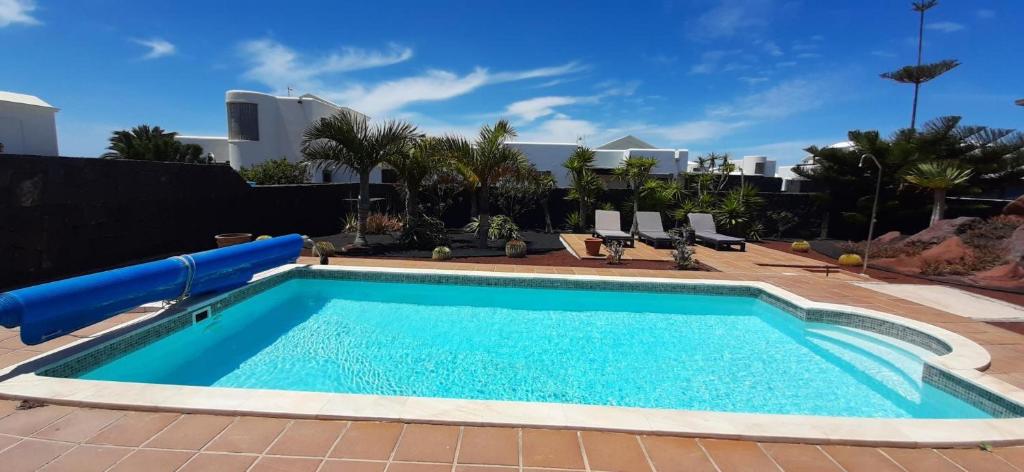 a swimming pool with a water slide in a yard at Villa Adais in Playa Blanca