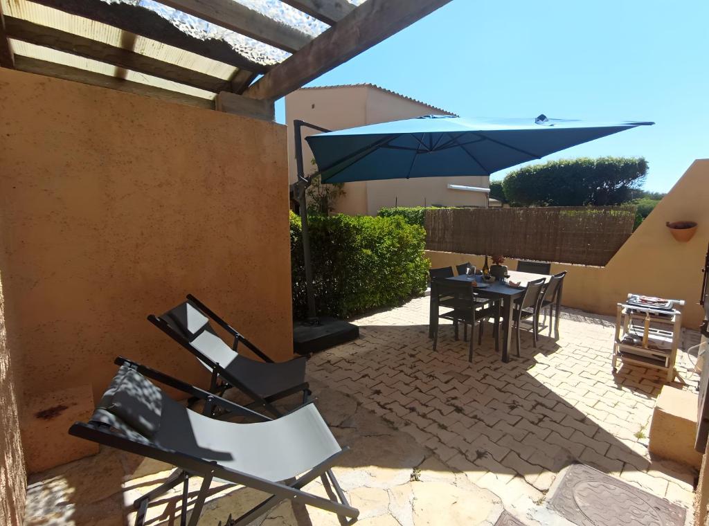 a patio with a table and chairs and an umbrella at Gîte Capibay Les Herbes de Provence in Six-Fours-les-Plages