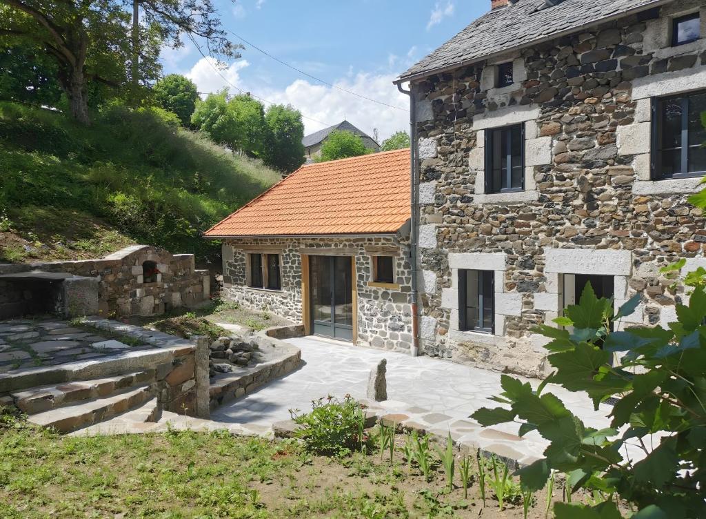 a stone house with a courtyard in front of it at Gîte La Forge Faverolles in Arcomie