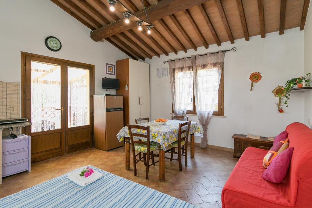 a living room with a red couch and a table at Il Pino - monolocale Lavanda in Cecina
