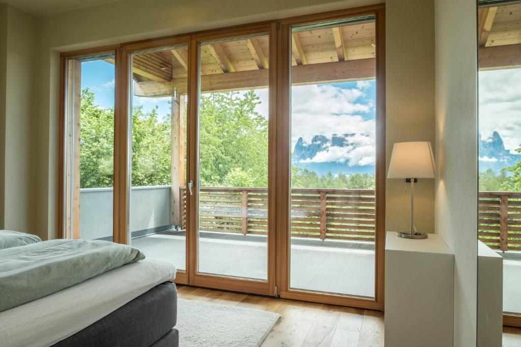 a bedroom with sliding glass doors and a balcony at Haus Lichtenstern in Soprabolzano
