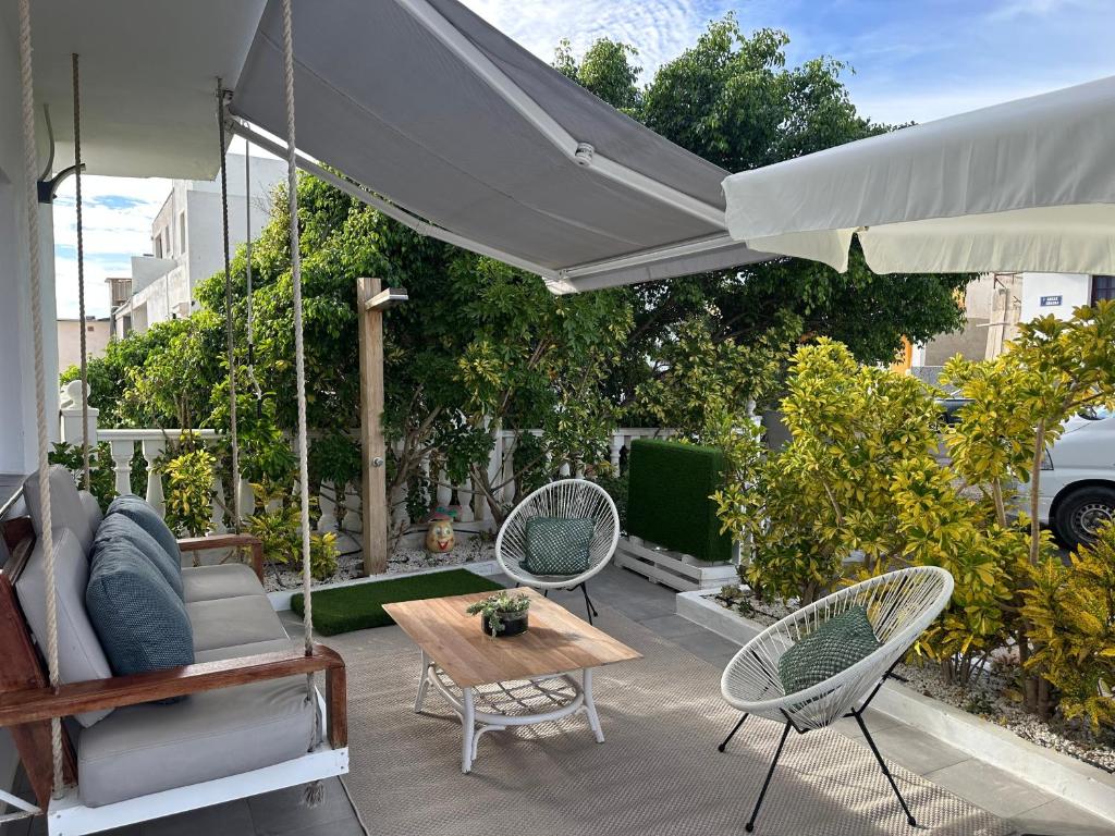 a patio with two chairs and a table and an umbrella at Casa Alba in Lomo de Arico