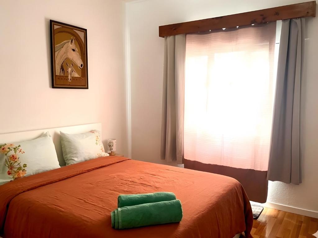 a bedroom with a bed with a green pillow on it at apartment near the airport in Ponta Delgada