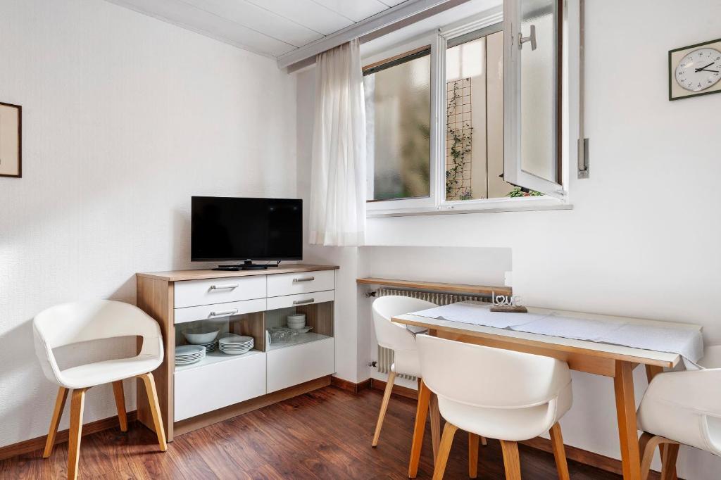 a room with a desk with chairs and a television at Haus Marlene in Cornedo all'Isarco