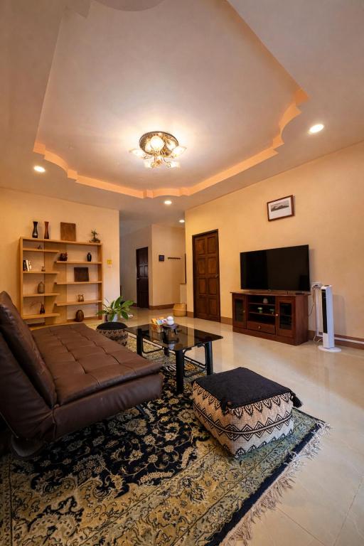 a large living room with a couch and a tv at Lilo House, Thaimueang Beach in Thai Muang