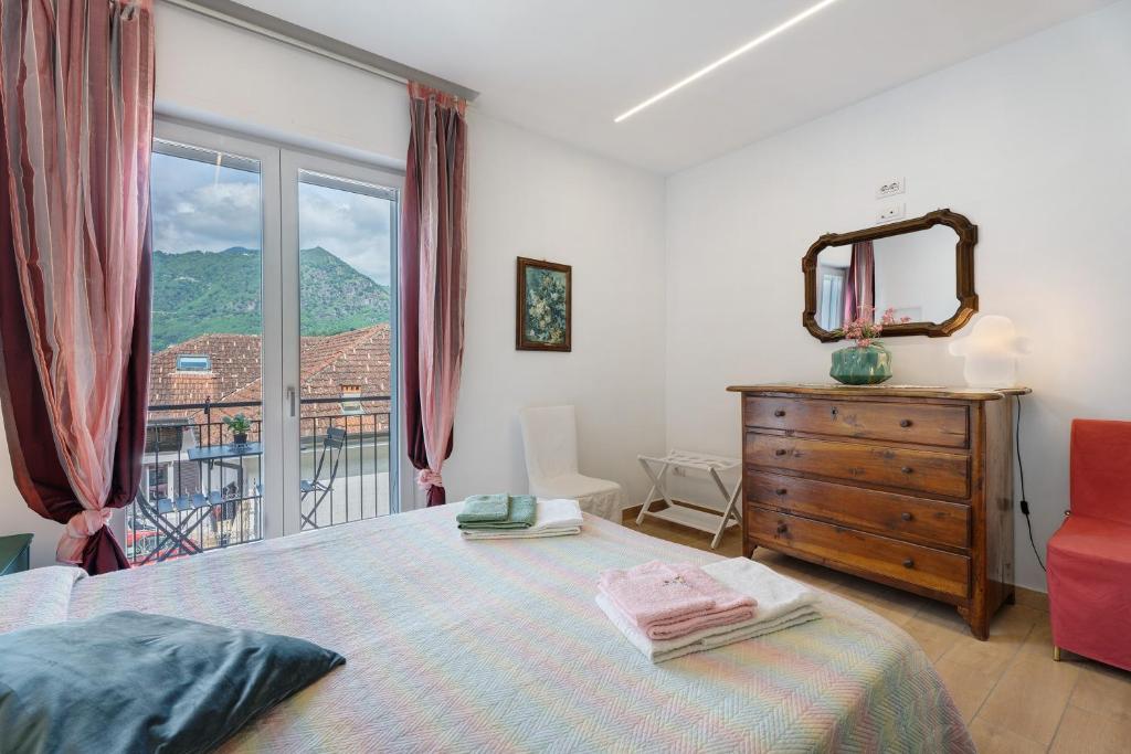 a bedroom with a bed and a dresser and a window at Casa Lago Vicky in Omegna