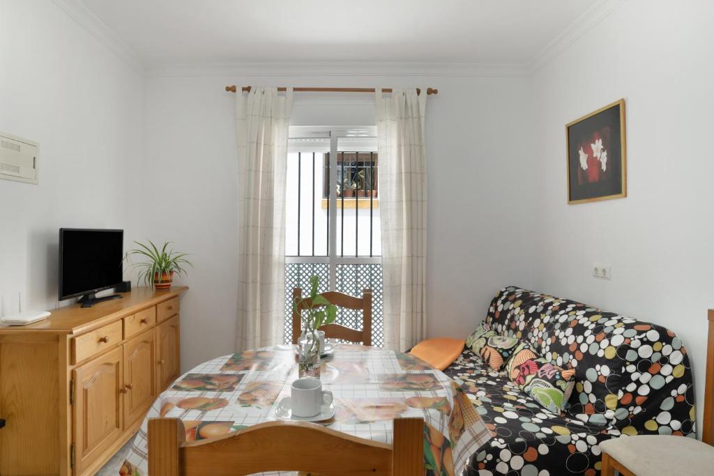 a living room with a table and a couch at Casa Paqui Bustos 1 in Conil de la Frontera