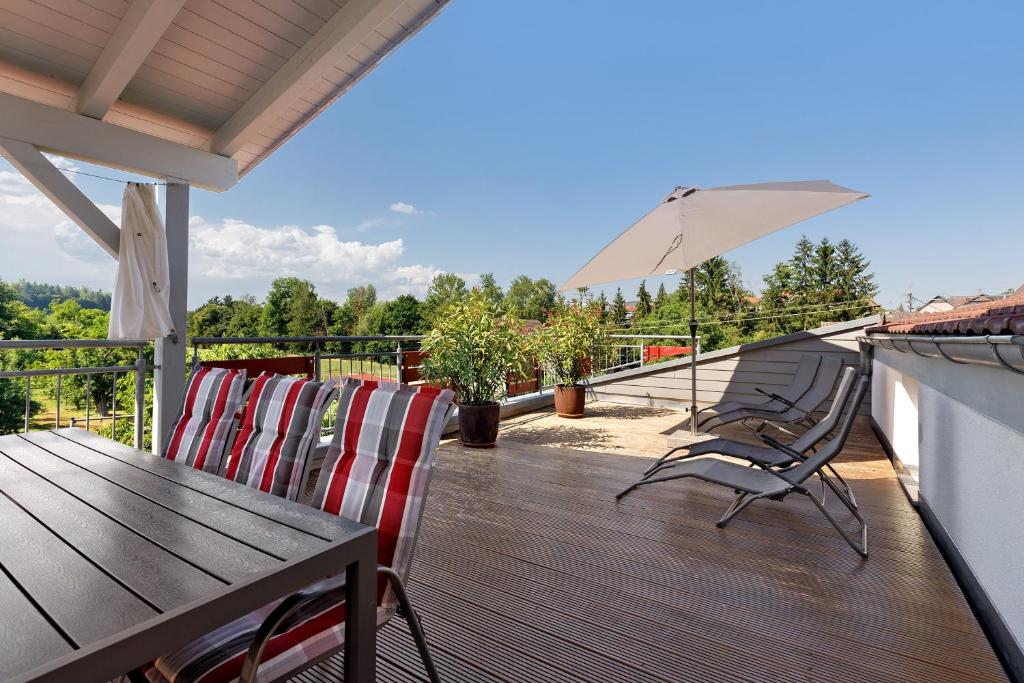 a deck with a table and chairs and an umbrella at Reiselust in Stockach